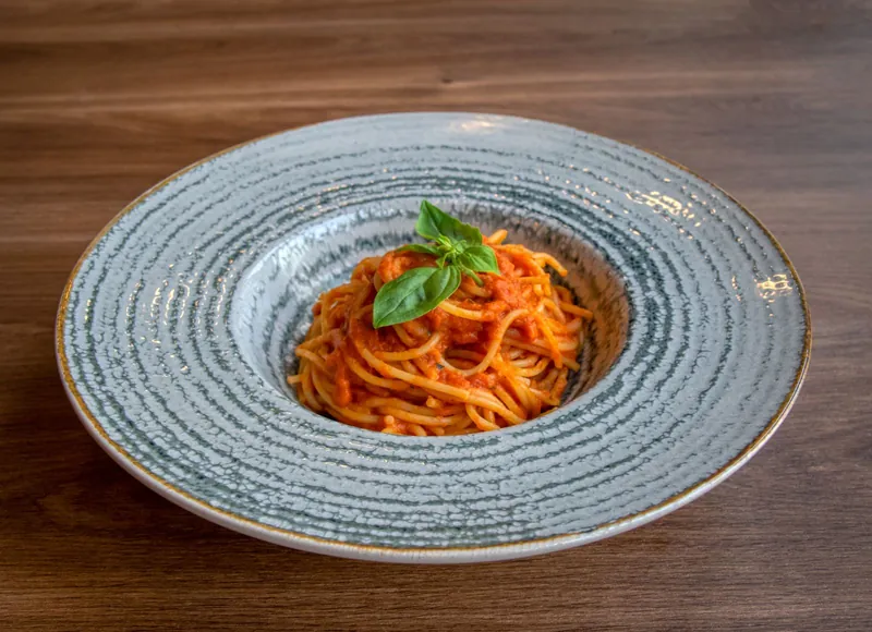 Spaghetti in tomato sauce topped with fresh basil